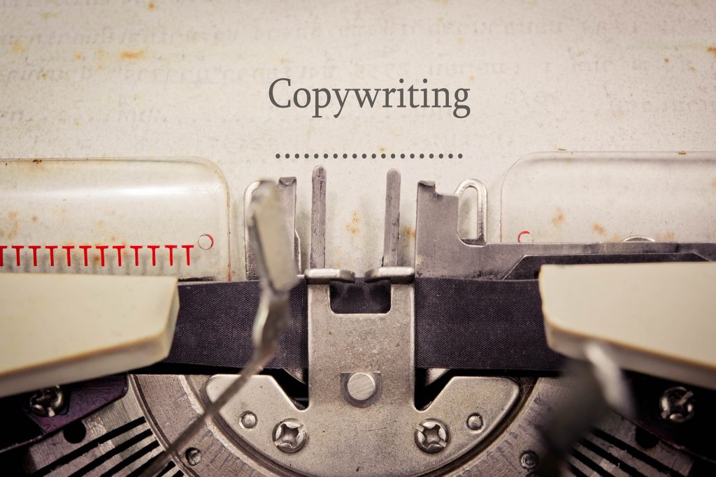 A picture of a typewriter with the word "Copywriting" on the paper with a line of dots underneath.